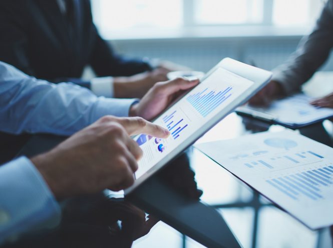 Image of businessperson pointing at document in touchpad at meeting